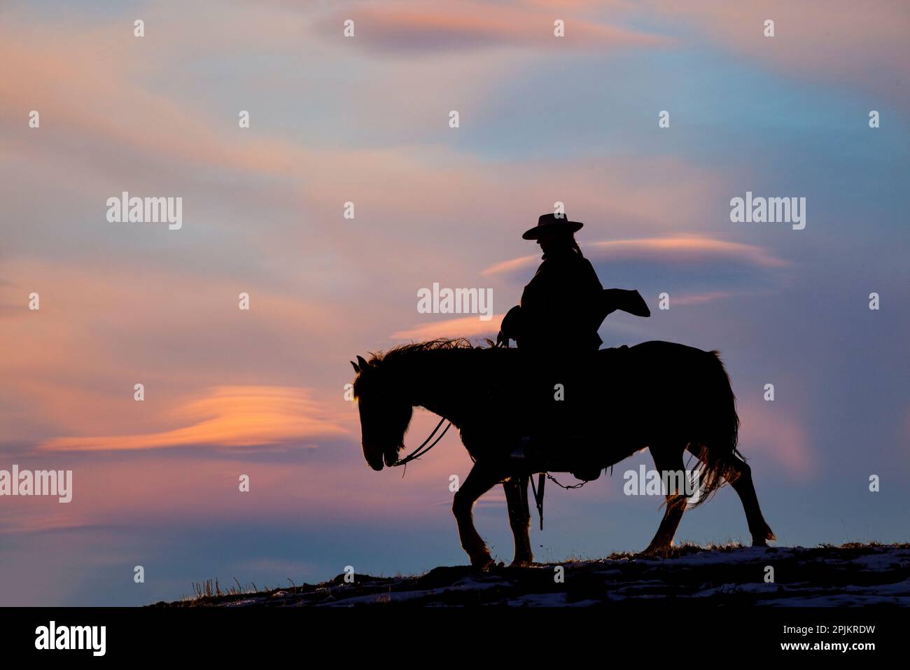 USA, Shell, Wyoming. Versteck Ranch Cowgirl auf dem Pferd bei Sonnenuntergang. (PR, MR) Stockfoto