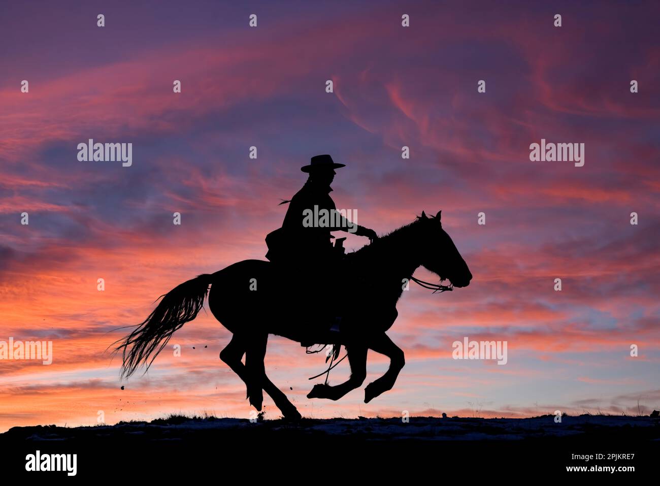 USA, Shell, Wyoming. Versteck Ranch Cowgirl auf dem Pferd bei Sonnenuntergang. (PR, MR) Stockfoto