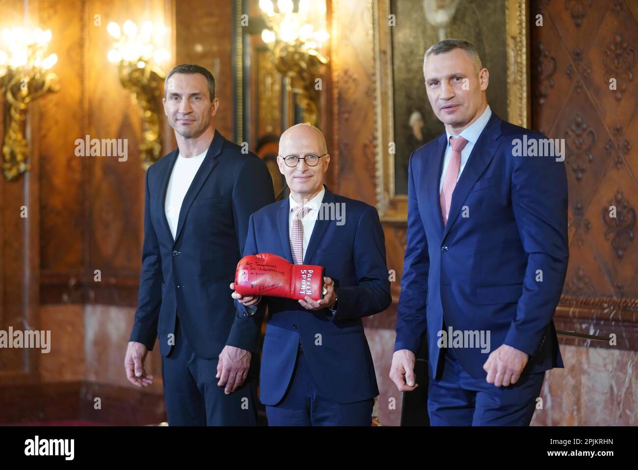 Hamburg: Deutschland, 03. April 2023, Peter Tschentscher (M, SPD), erster Bürgermeister und Präsident des Senats der Freien und Hansestadt Hamburg, steht zwischen Vitali Klitschko (r), Bürgermeister der ukrainischen Hauptstadt Kiew und ehemaliger Boxweltmeister, Und Bruder Wladimir Klitschko nach einer Pressekonferenz im Rathaus, mit einem Boxhandschuh mit einer Widmung der beiden ehemaligen Boxweltmeister. Klitschko und Tschentscher haben über die aktuelle Situation in Kiew und Ukraineprochensow über ihre weitere Zusammenarbeit im "Pakt für Solidarität und Zukunft" gesprochen. Im April 2022 wurden die beiden Po Stockfoto