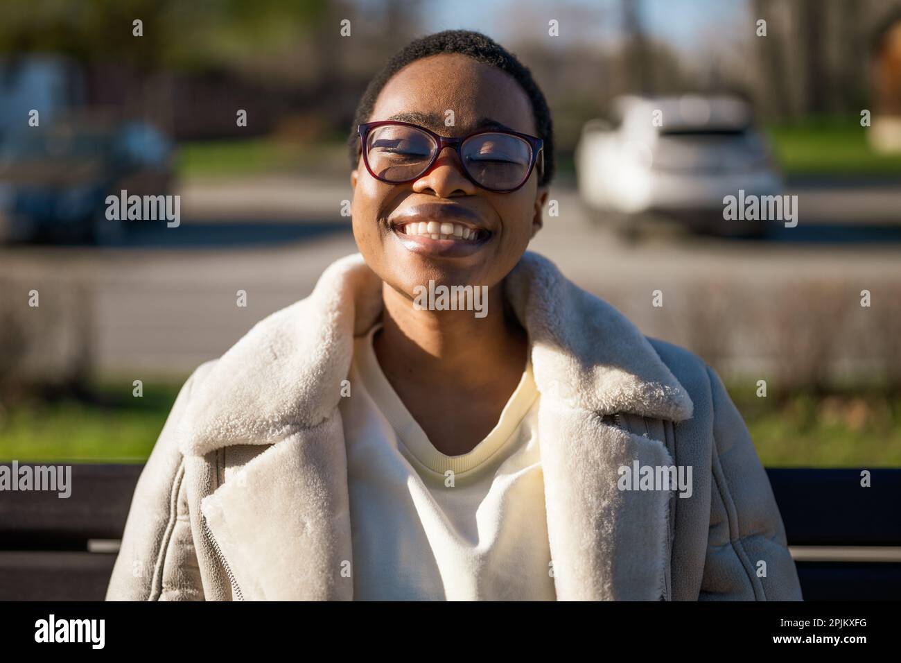Nahaufnahme einer glücklichen afroamerikanischen Frau im Freien. Sie genießt die Sonne und die frische Luft. Stockfoto