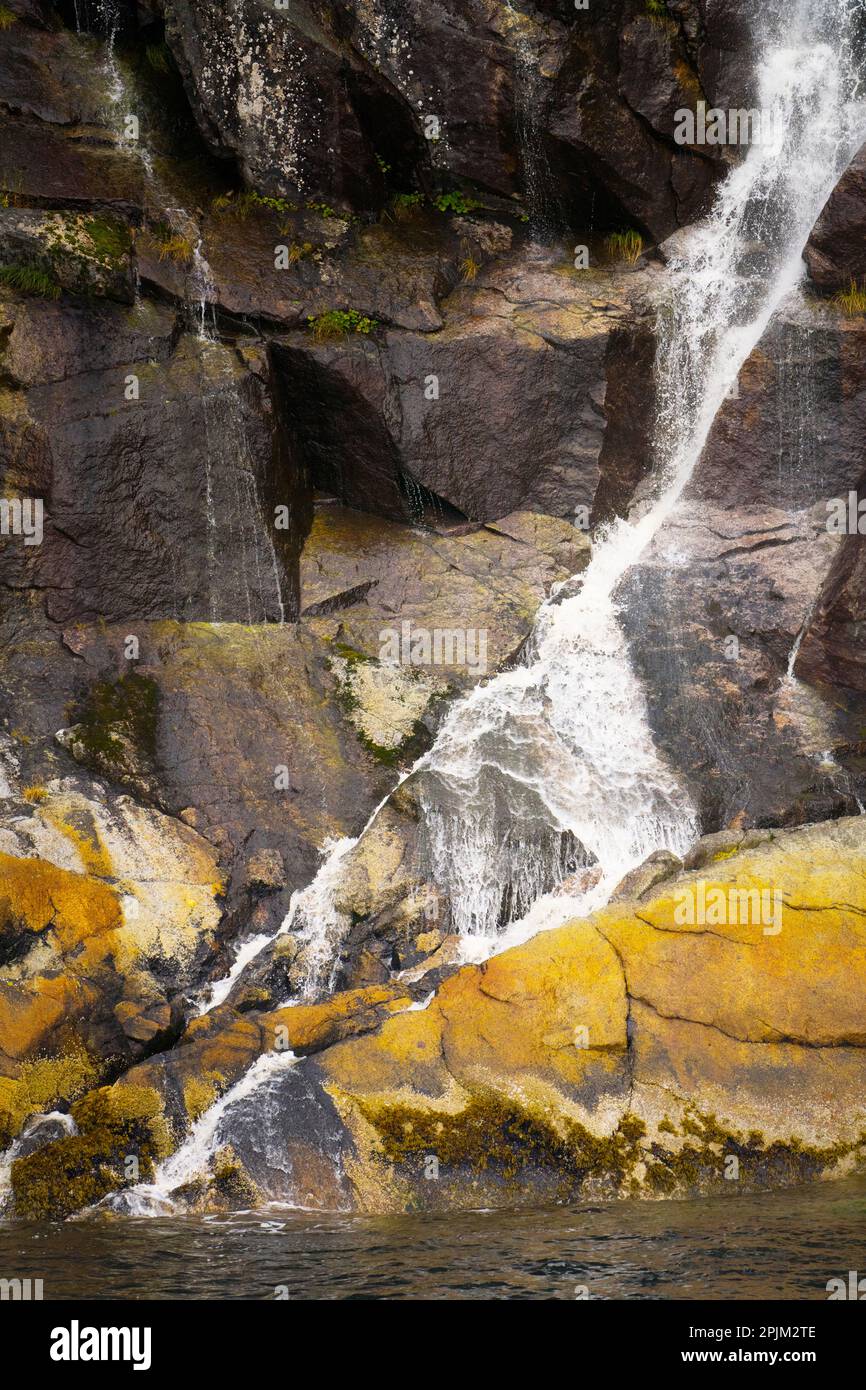 Nahaufnahme des Wasserfalls über bunten Felsen Stockfoto