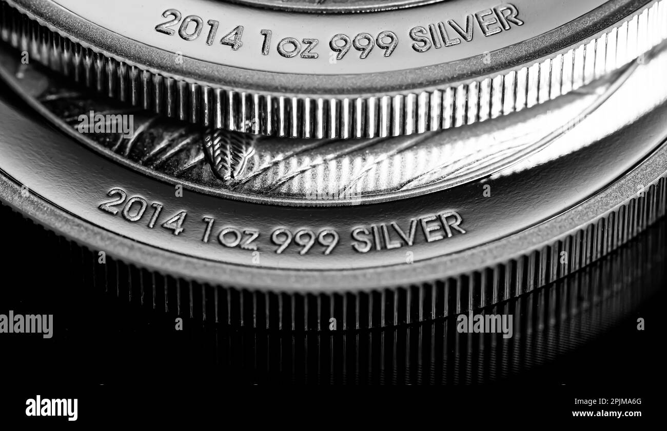 Makro-Nahaufnahme der Silberbargeldmünze auf einem schwarzen Spiegelhintergrund Stockfoto