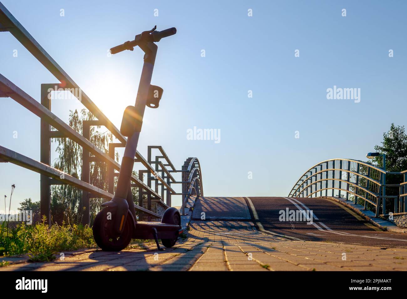 Ein Roller vor dem Hintergrund von Himmel und Sonne. Ein mobiles Transportmittel in der Stadt Stockfoto