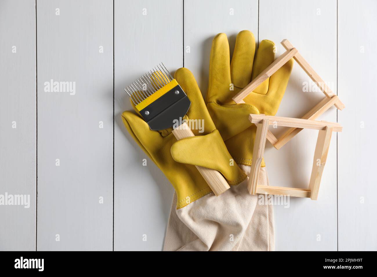 Wabenrahmen und Imkereiwerkzeuge auf weißem Holztisch, flach liegend. Platz für Text Stockfoto