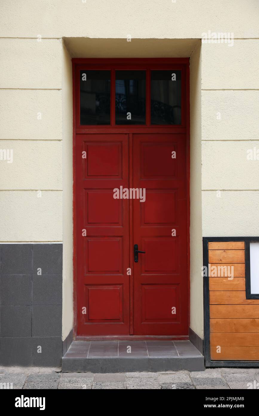 Eingang des Hauses mit wunderschöner roter Tür und Heckfenster Stockfoto