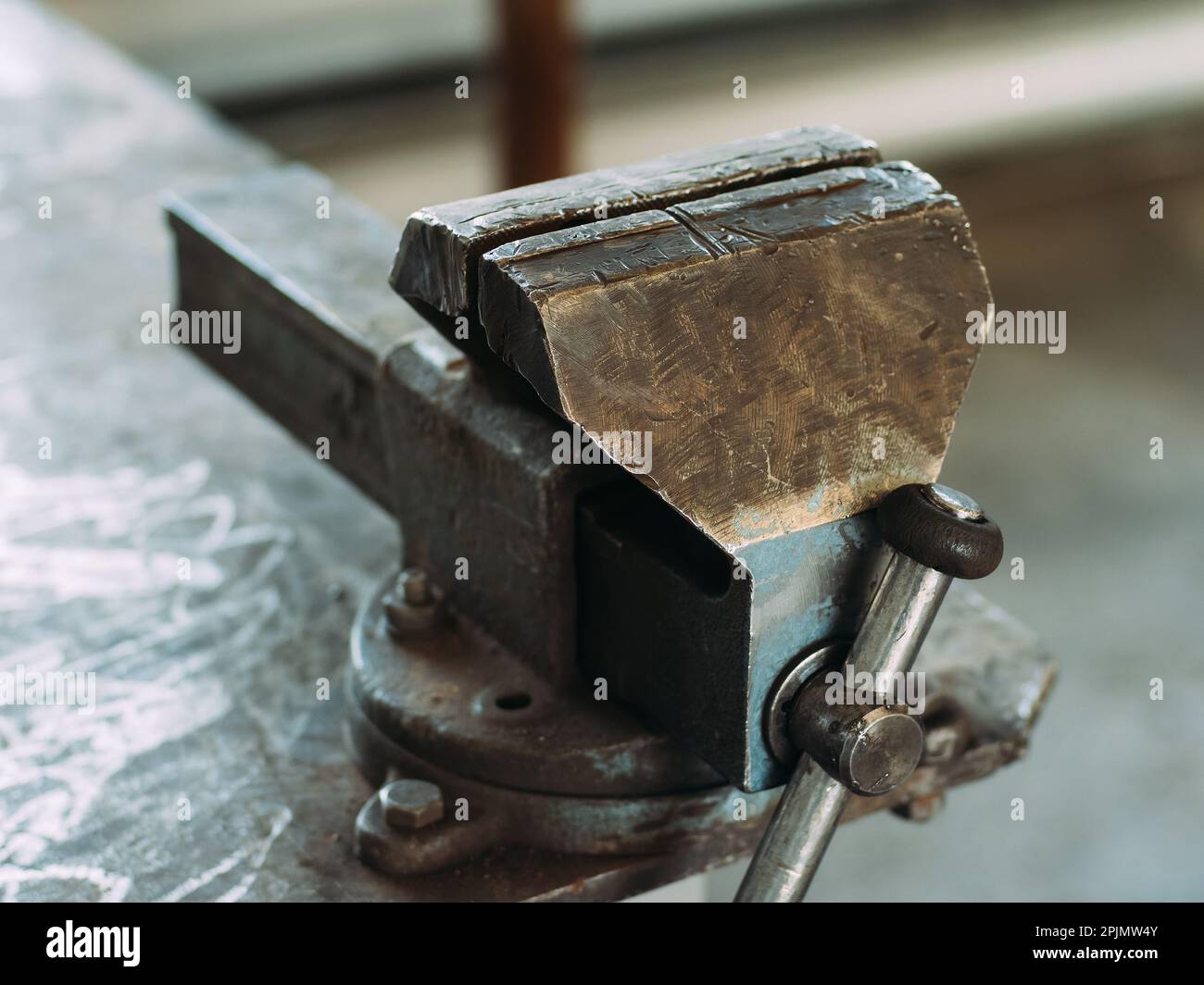 Werkbank aus Metall mit Viskel zum Spannen von Teilen. Ansicht des Arbeitsplatzes in der Werkstatt. Ordnung und Sauberkeit am Arbeitsplatz. Stockfoto