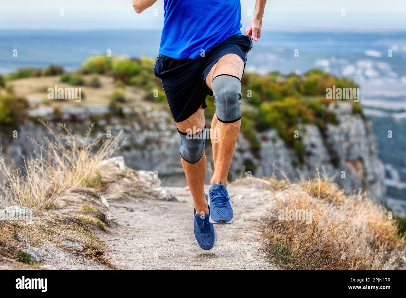 Beinläufer in Knieschützern auf Bergwanderwegen, Knieschutzmanschette nach Verletzung der Stabilisierungsbeine Stockfoto