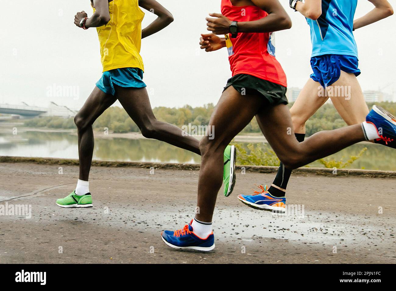 Gruppe afrikanischer und europäischer Läufer beim Marathonrennen, Legs Jogger beim Weltmeisterschaftsrennen Stockfoto