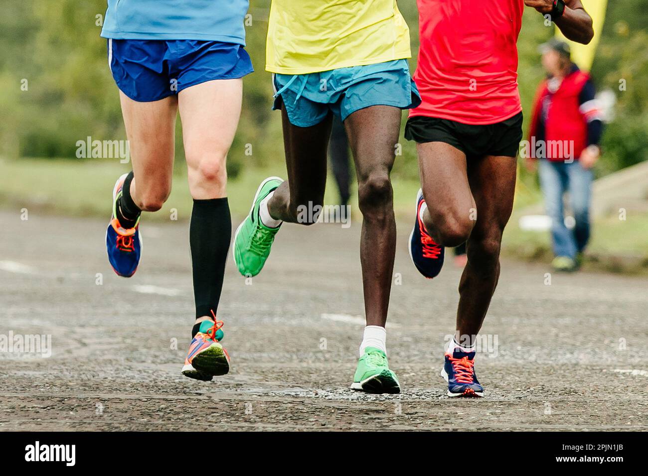 Zwei afrikanische und europäische Läufer laufen Marathon und zeigen die Beine von vorne. Jogger laufen Weltmeisterschaftsrennen Stockfoto