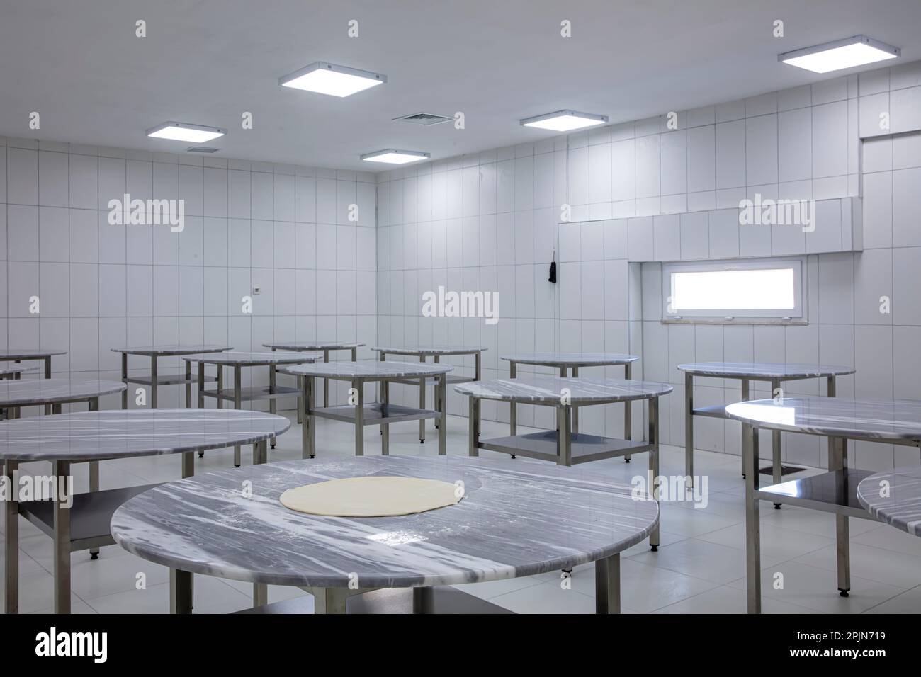 Modernisierung von Lebensmittelverarbeitungsanlagen, Produktionslinien. Herstellung einer Brotbackfabrik mit frischen Produkten. Lebensmittelfabrik mit Marmortischen U Stockfoto