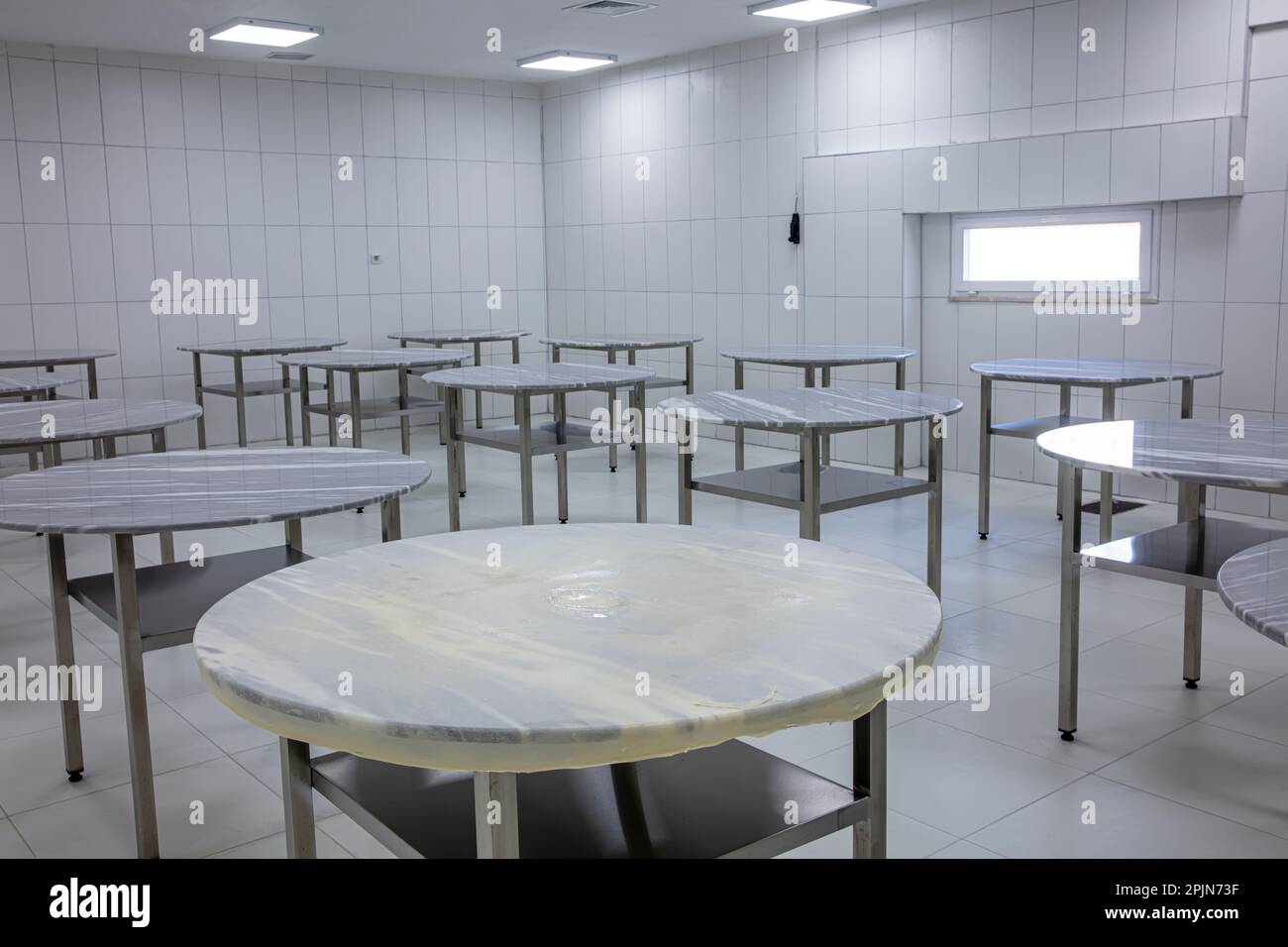 Modernisierung von Lebensmittelverarbeitungsanlagen, Produktionslinien. Herstellung einer Brotbackfabrik mit frischen Produkten. Lebensmittelfabrik mit Marmortischen U Stockfoto