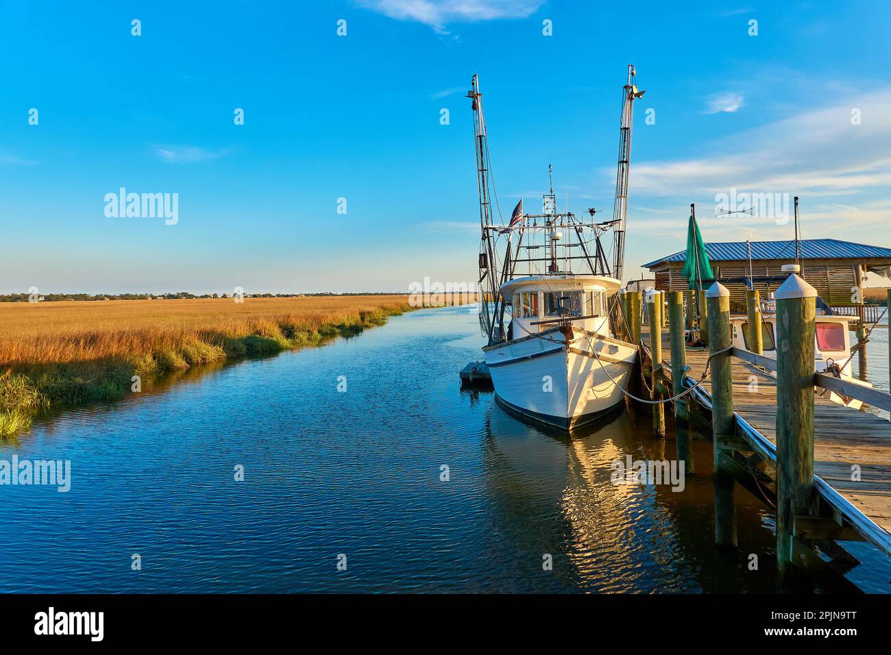 Sonnenuntergang mit Garnelenboot entlang einer Anlegestelle auf Tybee Island, Georgia Stockfoto