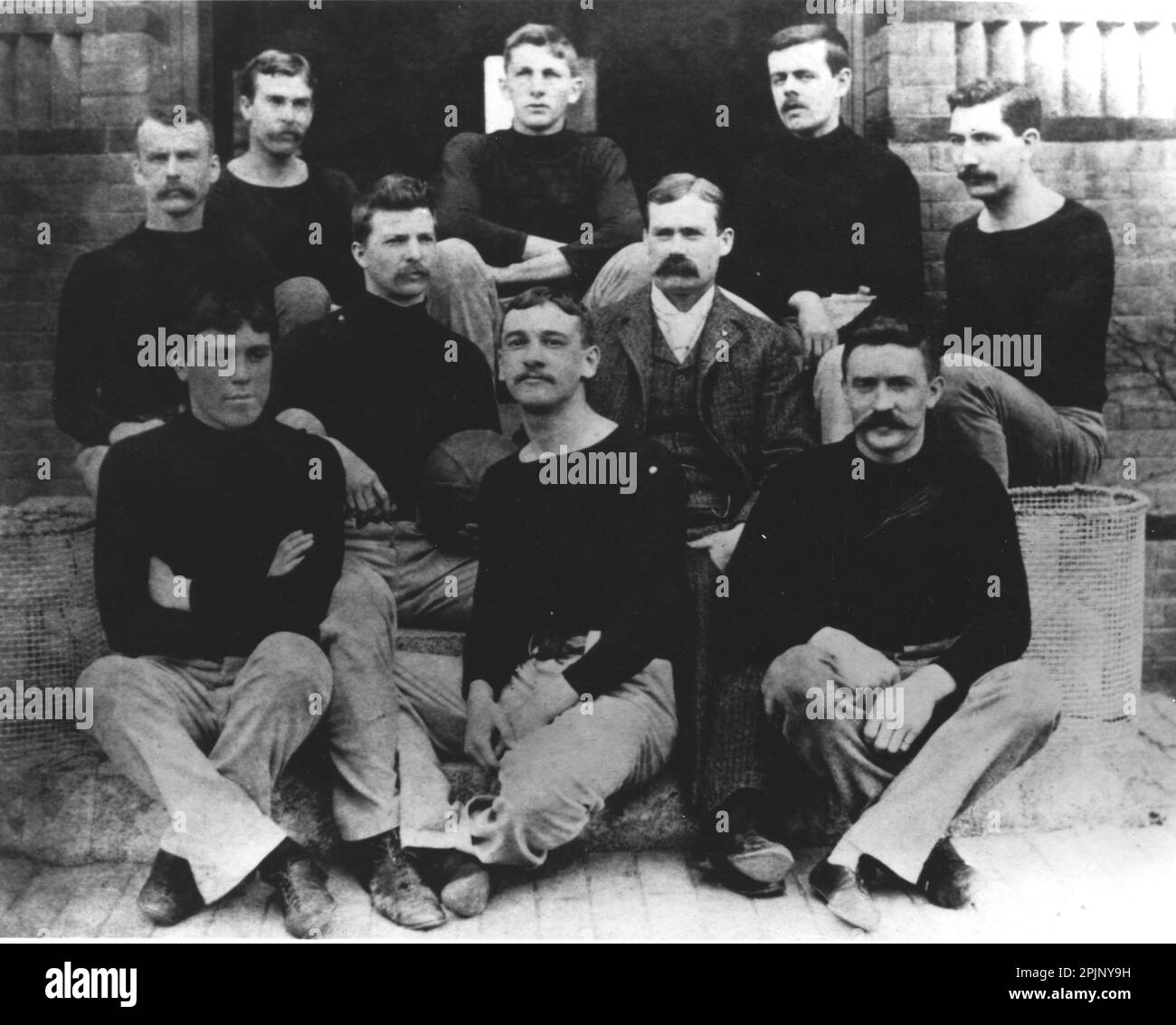 Dr. James Naismith (Anzug), Lehrer am Springfield College und Basketballerfinder, posierte mit dem „First Team“. Das erste Spiel wurde 1891 gespielt, um Naismith einen Auftrag zu erteilen, ein Spiel zu entwickeln, das zwischen der Fußball- und Baseballsaison in Innenräumen gespielt werden kann. Springfield, MA, 12/1891. (NARA/Springfield College) Stockfoto