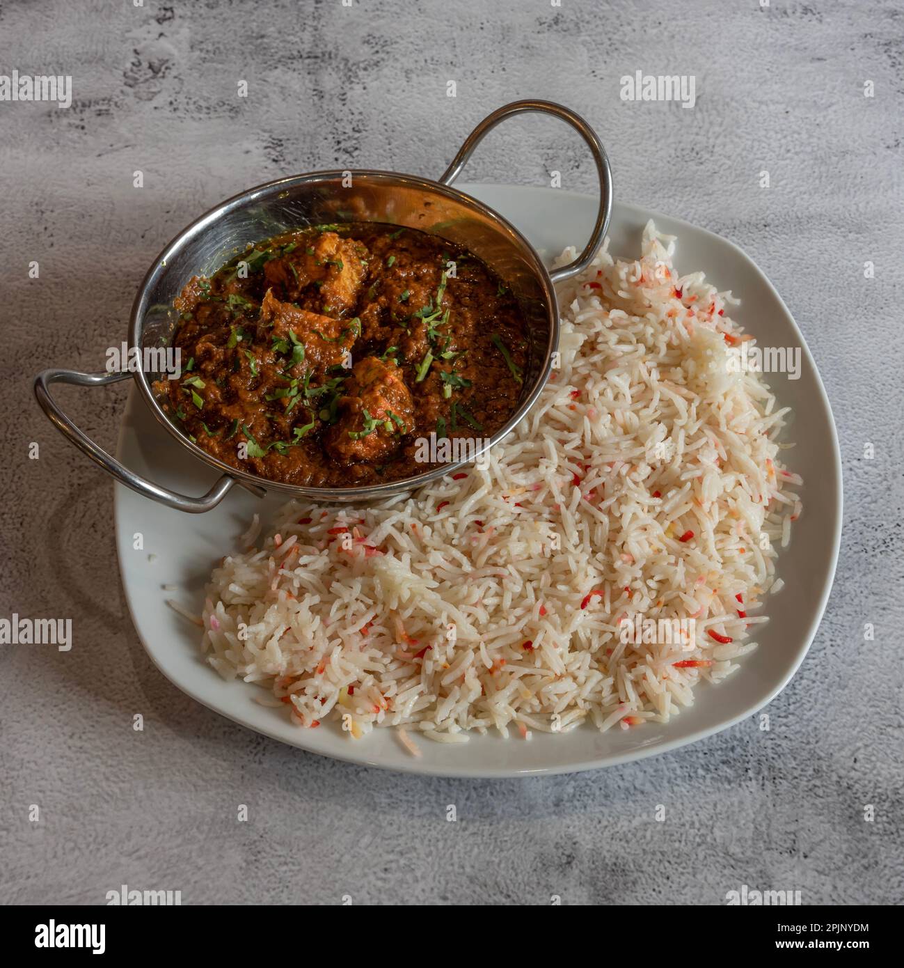 Indische Dishe kulinarisches Still Life. Hähnchen Tikka Massala serviert mit Reis auf einem Teller Stockfoto