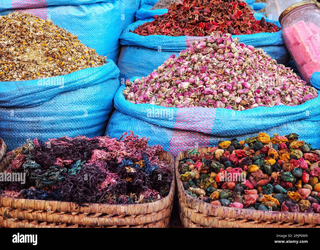 Stapel getrockneter Rosen und anderer Blumen, die als natürliche Düfte verwendet werden, werden auf dem Souk - dem traditionellen Straßenmarkt in Marokko - präsentiert Stockfoto