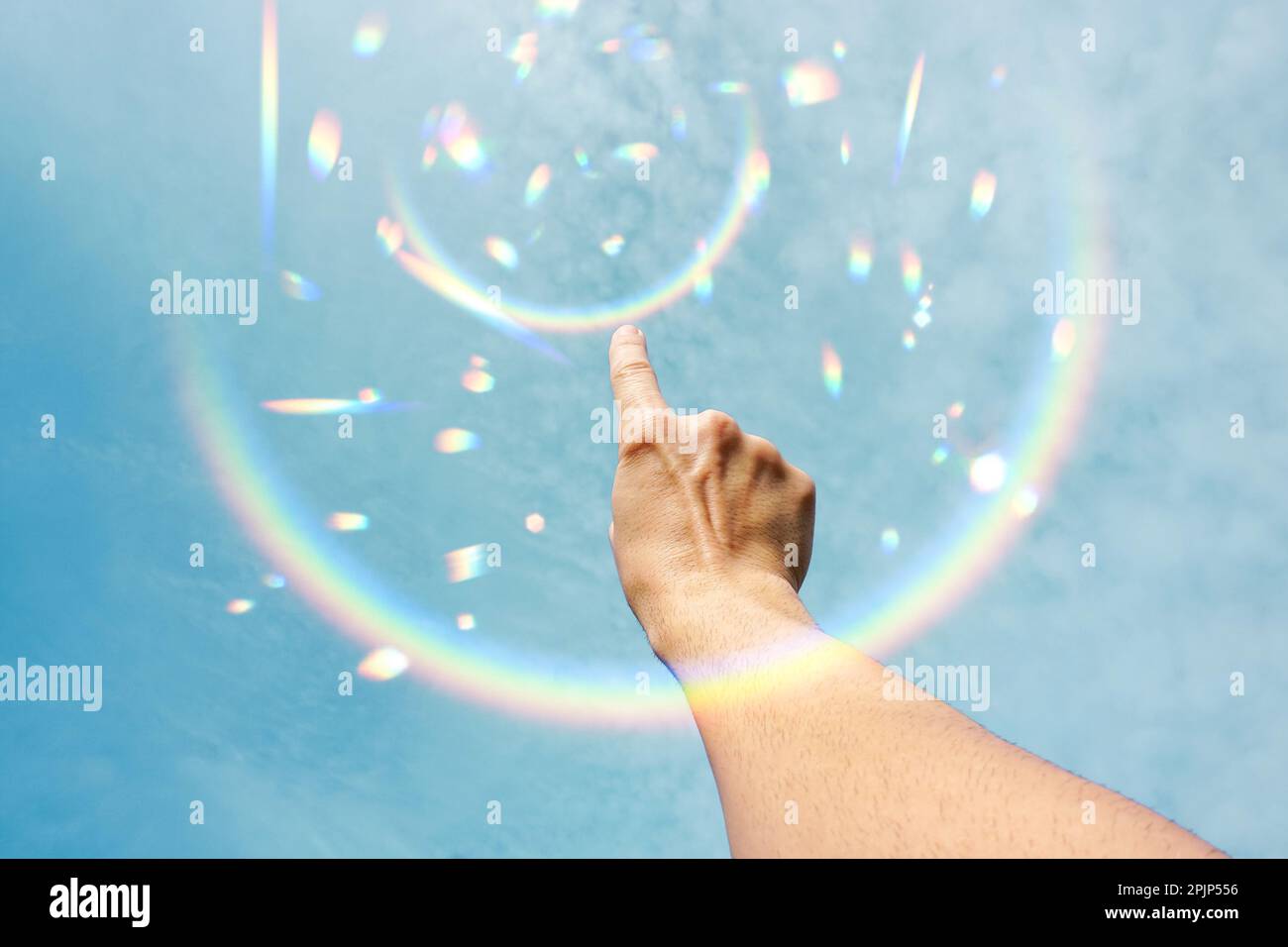 Die Hand erhob sich im blauen Himmel, als Gesten mit dem Sonnenlicht Stockfoto