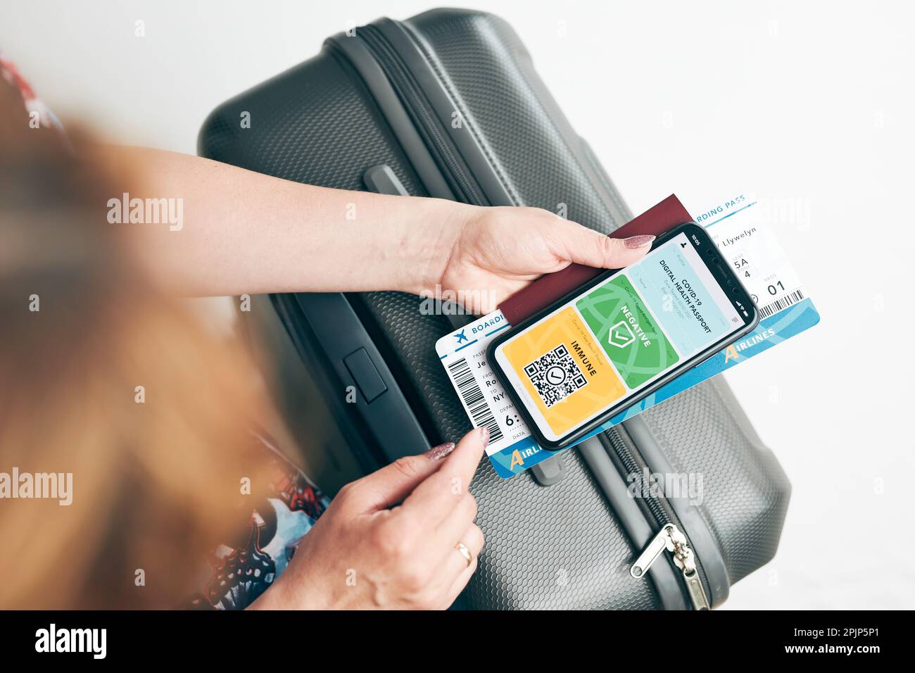 Digitales Covid-Zertifikat. Covid negativer schneller digitaler Test bestanden. Passagierin mit digitalem medizinischem Pass auf Mobiltelefon, Reisepass und Luftwaffe Stockfoto