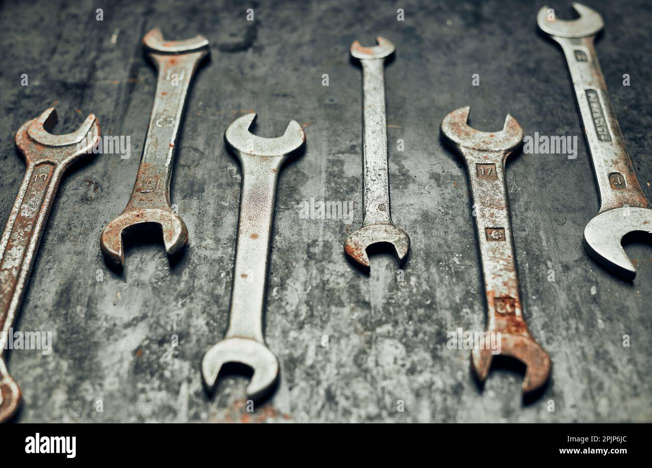 Schraubenschlüssel auf Stahloberfläche. Alte rostige Schraubenschlüssel zur Wartung. Mechanische Hardware-Tools zu reparieren. Technische Tools Hintergrund mit Kopierplatz Stockfoto
