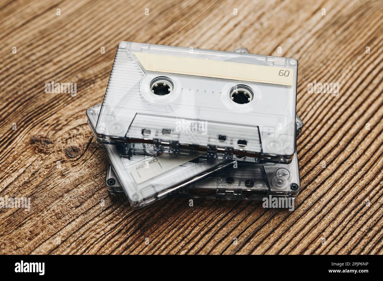 Bandkassetten. Magnetische Kassettenbänder auf Holztisch. Retro-Musikstil. 80s Uhr Musikparty. Vintage-Style. Analoge Geräte. Stereo-Sound Stockfoto