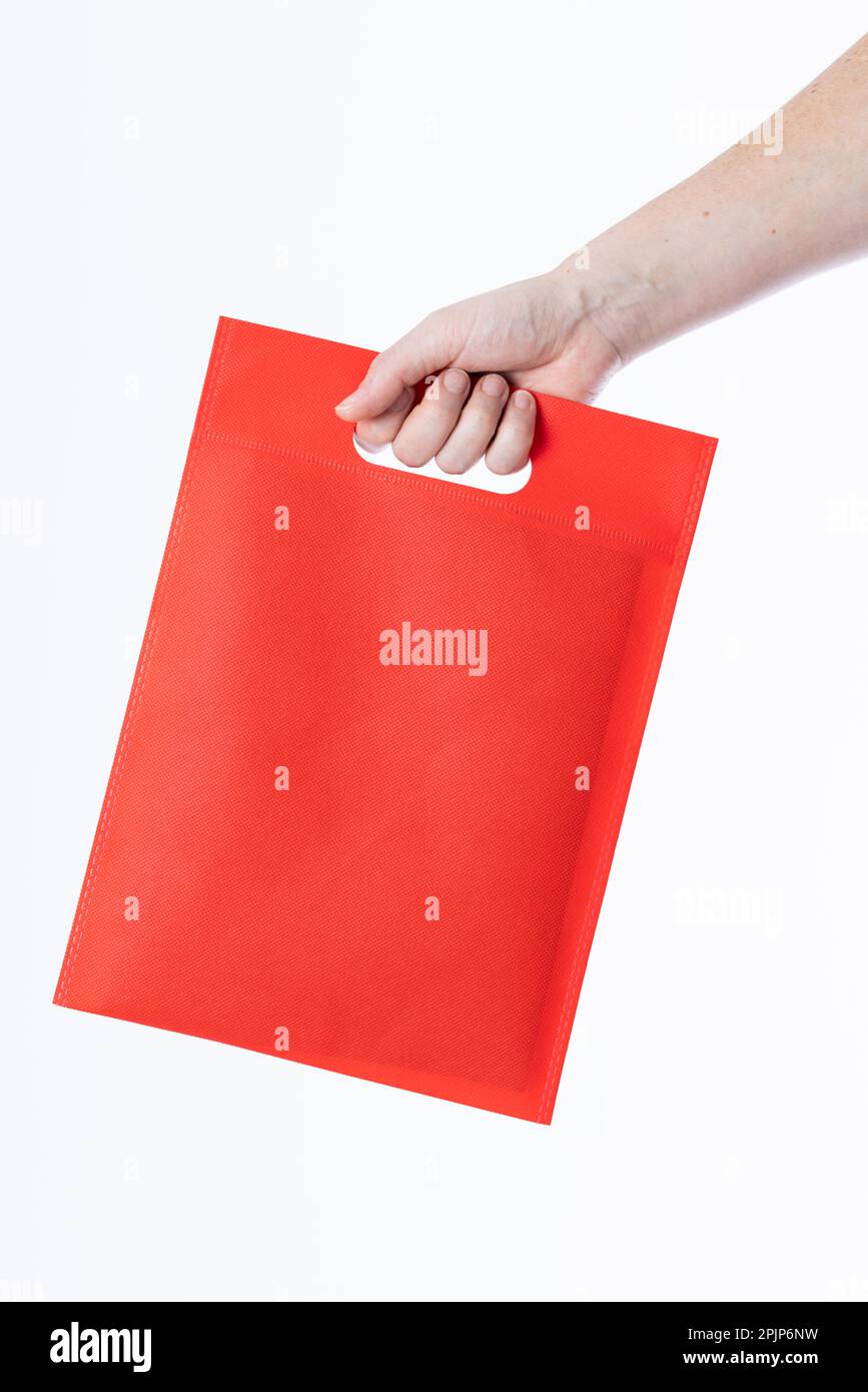 Hand einer weißen Frau mit roter Tasche und Kopierbereich auf weißem Hintergrund Stockfoto