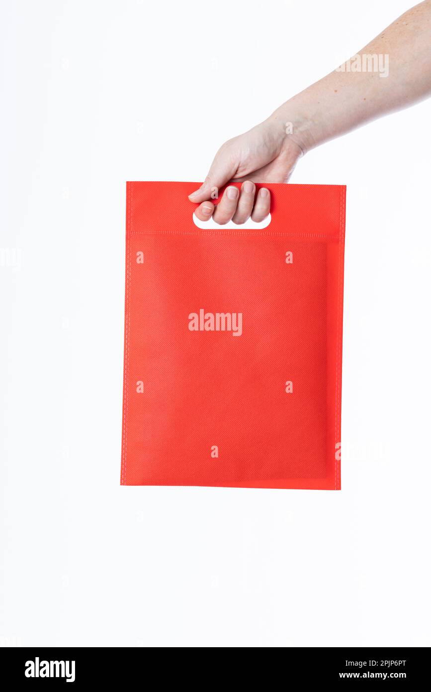 Hand einer weißen Frau mit roter Tasche und Kopierbereich auf weißem Hintergrund Stockfoto