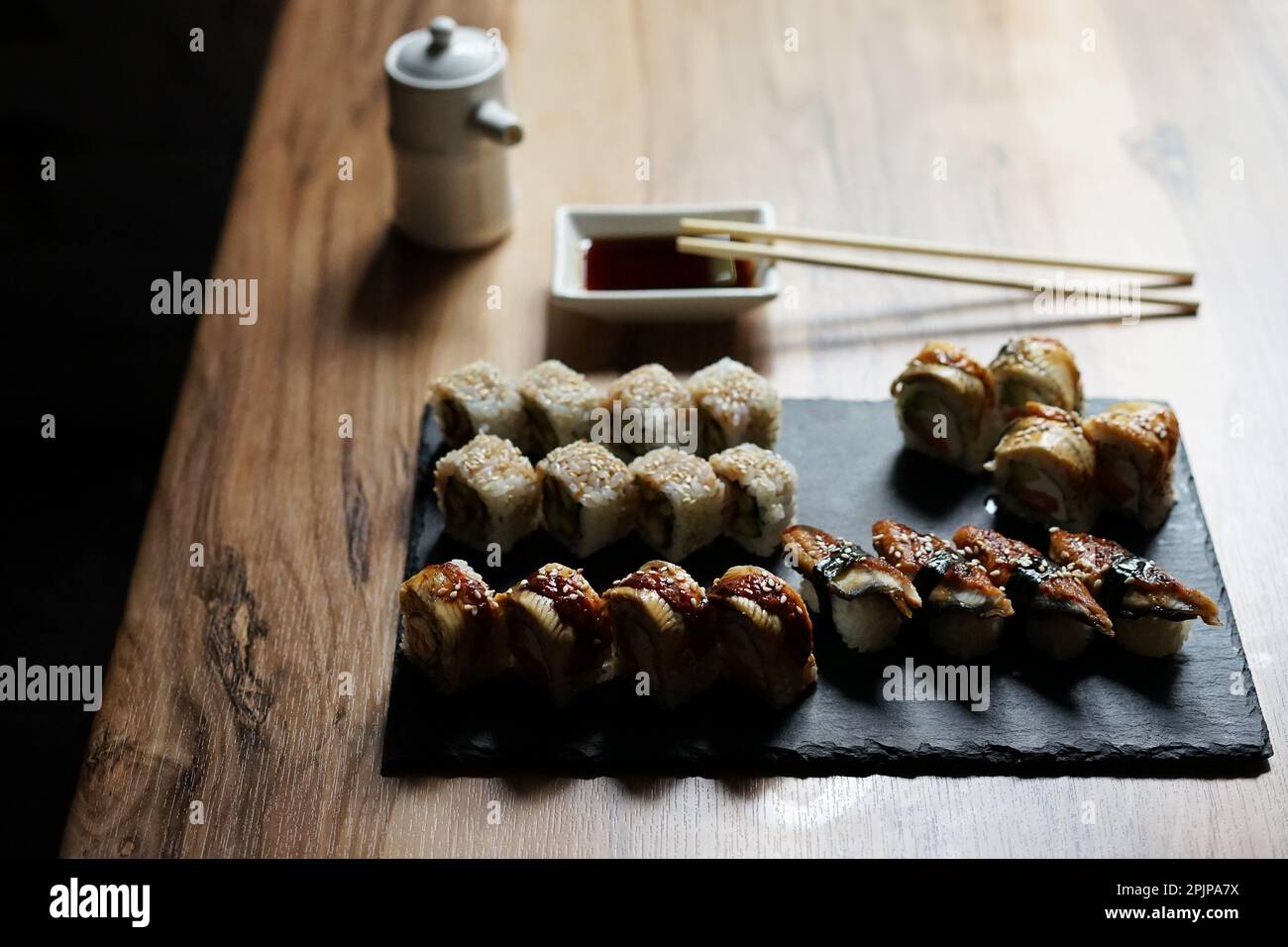 Japanische Küche: Brötchen und Sojasauce auf Holztisch Stockfoto