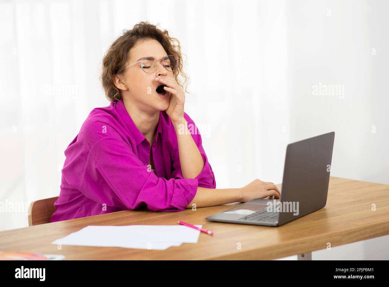 Schläfrige Freiberuflerin Gähnt Am Arbeitsplatz Im Home Office, Stockfoto