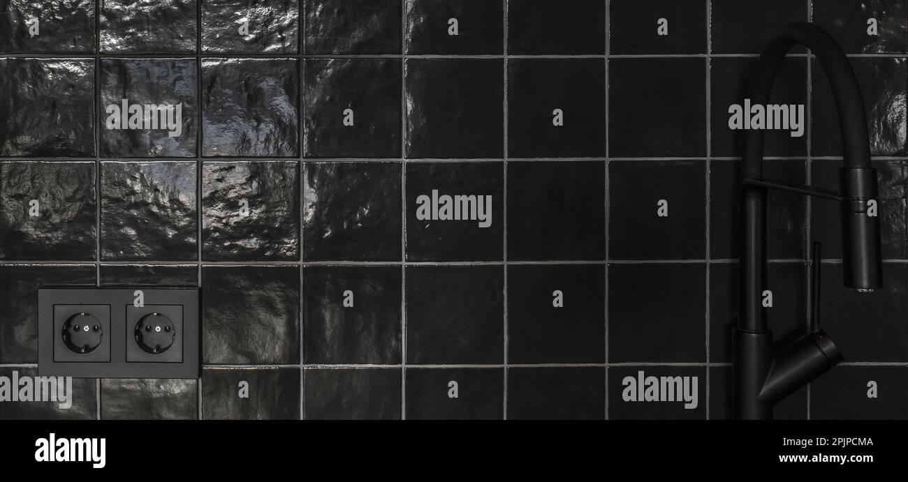 Kleine Kücheneinrichtung in grauen und schwarzen Farben, Betonwände, schwarze Fliesen. Zeitgenössische Innenraumgestaltung Stockfoto