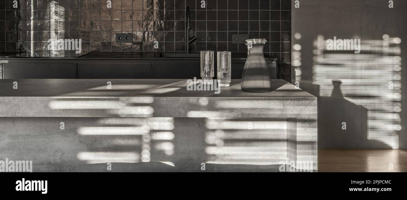 Kleine Kücheneinrichtung in grauen und schwarzen Farben, Betonwände, Glasschiebetüren. Zeitgenössisches Innendesign mit Betondetektor Stockfoto