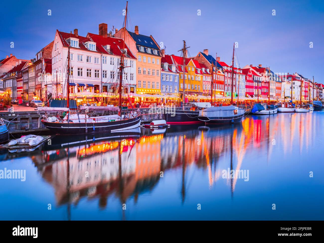 Der Charme von Kopenhagen, Dänemark in Nyhavn. Legendärer Kanal, farbenfrohe Morgendämmerung mit atemberaubenden Wasserreflexionen. Stockfoto