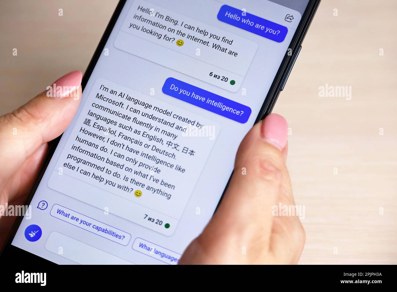 Online-Chat mit künstlicher Intelligenz in der mobilen App Bing von Microsoft. Smartphone in weiblichen Händen Stockfoto