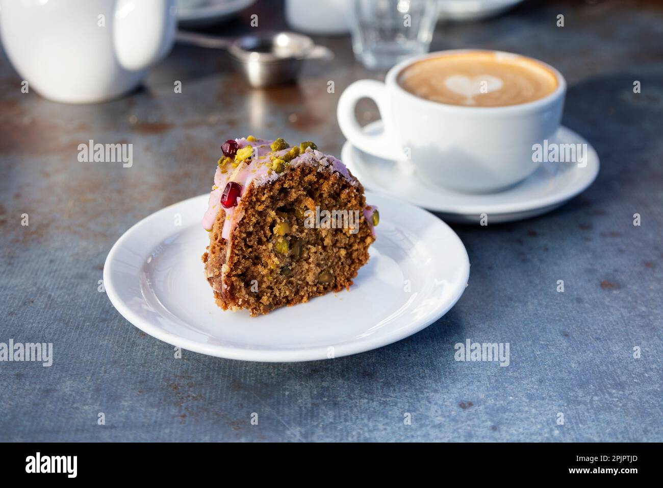 Granatapfelkuchen, Pistazien und Kardamon mit Kaffee im Petersham Nurseries Cafe, Richmond, London, Großbritannien Stockfoto