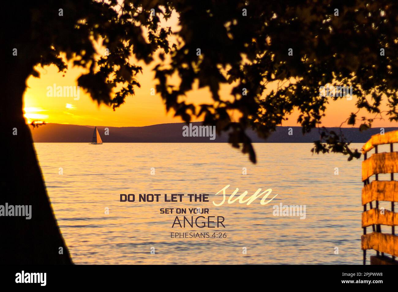 "Lass die Sonne nicht auf deiner Wut untergehen", Zitat aus der Bibel. Sonnenuntergang über dem See mit Baumsilhouette Stockfoto