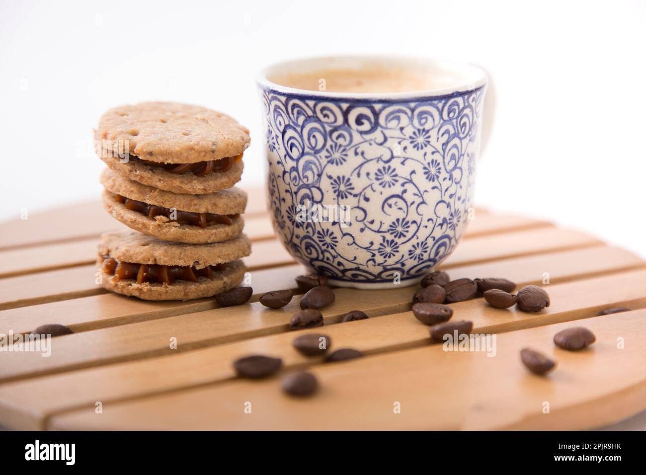 Eine kleine Tasse Kaffee mit französischen Pressekeksen und Kaffeebohnen Stockfoto