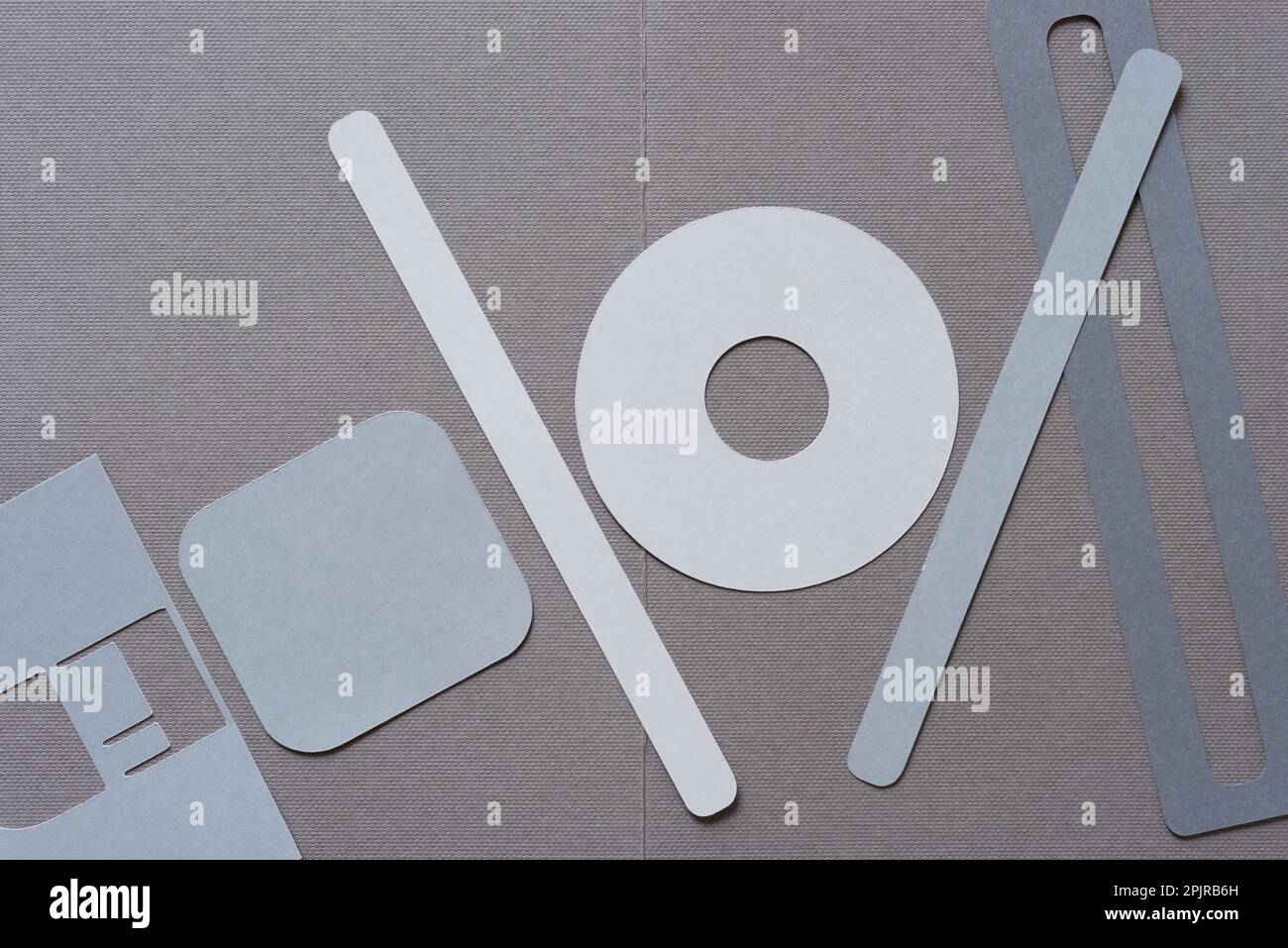 Schablone mit (mindestens) Buchstaben E, Quadrat mit abgerundeten Ecken, Ring und Stäbchen oder verschiedene Papierformen auf Grau Stockfoto