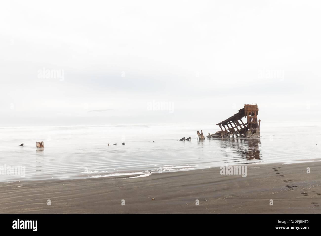 Fußabdrücke, die zum Wrack von Peter Iredale im Pazifik führen Stockfoto
