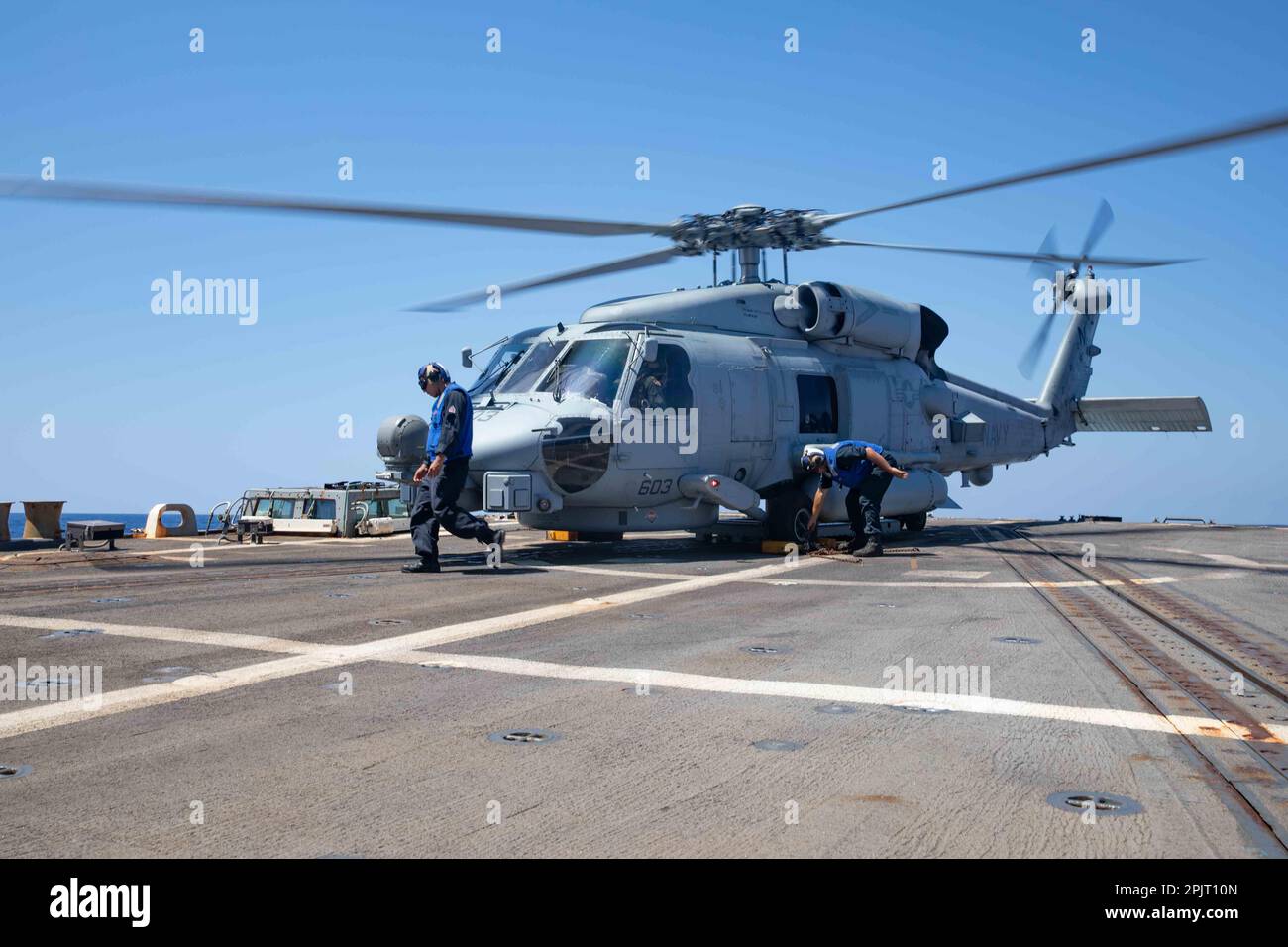 230329-N-WQ732-1005 KARIBISCHE SEE (29. März 2023) – Seeleute, die dem Arleigh-Burke-Klasse-geführten Raketenzerstörer USS Farragut (DDG 99) zugeteilt sind, entfernen den Keil und die Ketten von einem MH-60R Seahawk, der an die „Jaguars“ des Maritime Helicopter Strike Squadron (HSM 60) angeschlossen ist, März 29. Die USS Farragut wird in das US-Flottengebiet 4. entsandt, um die Mission des Destroyer-Geschwaders 40/Commander der Task Force 15 zu unterstützen. Die Mission umfasst kombinierte Marineeinsätze, den Aufbau von Partnerschaften und die Tätigkeit als Dienstleister für die Gemeinsame Interinstitutionelle Task Force Süd-Mission durch Unterstützung der Bekämpfung illegaler Drogen Stockfoto