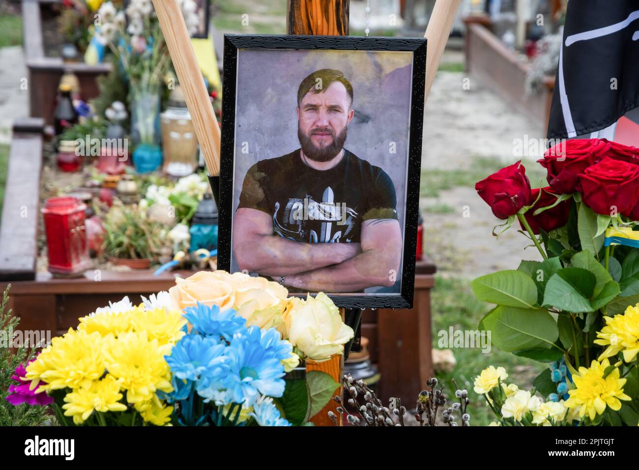 Das Grab eines gefallenen Soldaten mit einem Porträt auf dem Ehrenfeld auf dem Friedhof in Lemberg. Yurii Ruf war Schriftsteller, öffentliche Figur, Patriot der Ukraine und eine bekannte Person in Lemberg und der Ukraine. Er organisierte viele Veranstaltungen, ein Festival usw. Als der Krieg begann, ging er als Freiwilliger an die Front und wurde bei einer Kampfmission in der Region Luhansk am 1. April 2022 getötet. Das Ereignis auf den Fotos ist das Gedenken an Jurij in der Kirche und auf dem Feld der ehrenvollen Beerdigungen auf dem Friedhof Lychakivskyi in Lemberg am ersten Jahrestag seines Todes. Verwandte, Freunde und Bewohner von Stockfoto