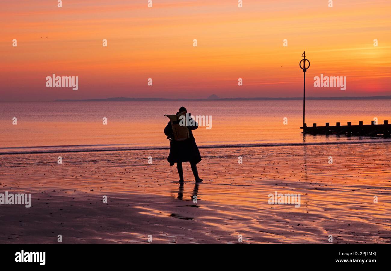 Portobello, Edinburgh, Schottland, Großbritannien. 4. April 2023 Ein männlicher Fotograf macht ein Foto kurz vor Sonnenaufgang am Firth of Forth. Kredit: Archwhite/alamy Live News. Stockfoto