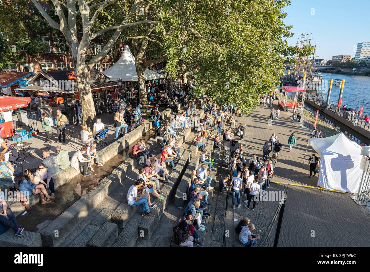 Menschen am Martime Day, Maritime Woche in Cafés und Bars am Schlachte die historische Uferpromenade am Weser mit Booten und Großseglern. Bremen. Stockfoto