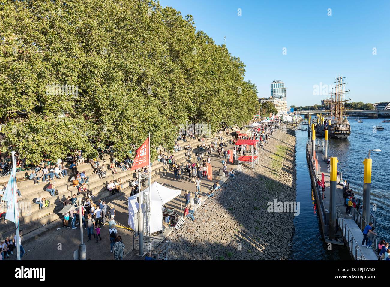 Menschen am Martime Day, Maritime Woche in Cafés und Bars am Schlachte die historische Uferpromenade am Weser mit Booten und Großseglern. Bremen. Stockfoto