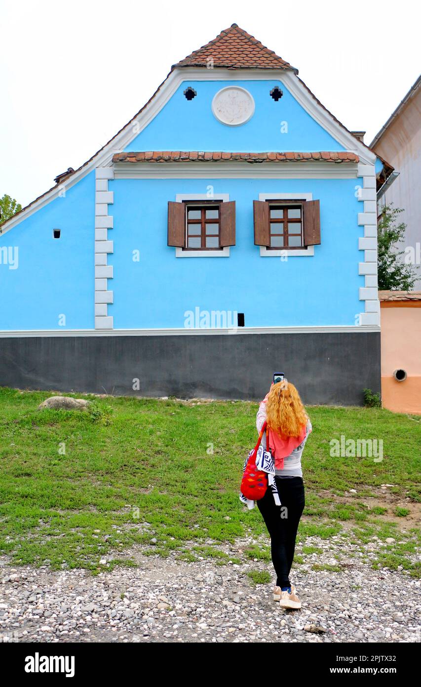 Frau, die in den sächsischen Dörfern - Visbri - von Siebenbürgen, Rumänien, reist. Reisender in Visbri, dem Lieblingsort von Prince Charles. Häuser mit tr Stockfoto