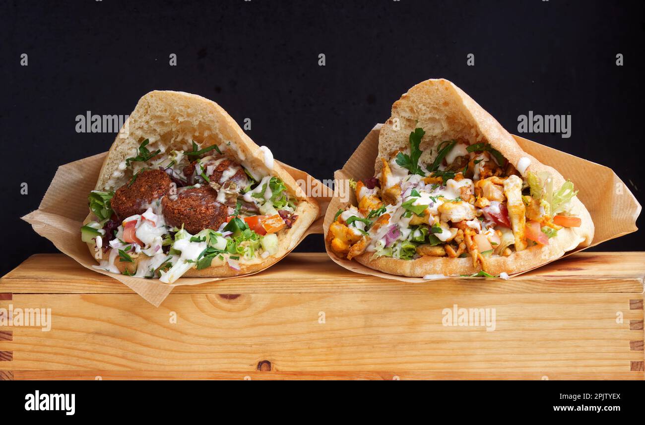 Fast Food im arabischen Stil, Pita-Brot gefüllt mit Falafel oder Hühnerfleisch mit Gemüsesalat und weißer Sauce auf dem Karlin Street Food Markt in Prag. Stockfoto