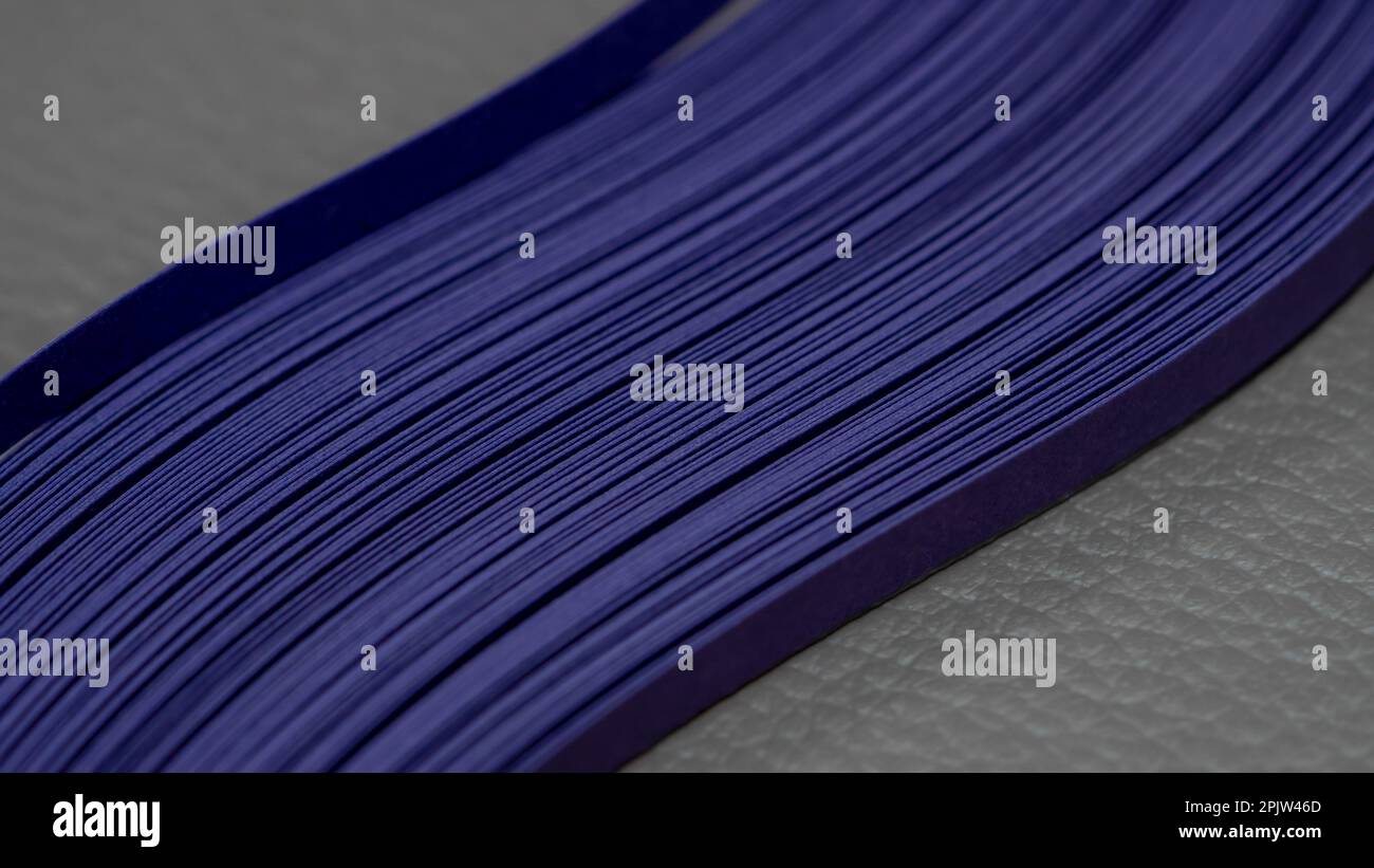 Violette Papierstreifen auf grauem Hintergrund Stockfoto
