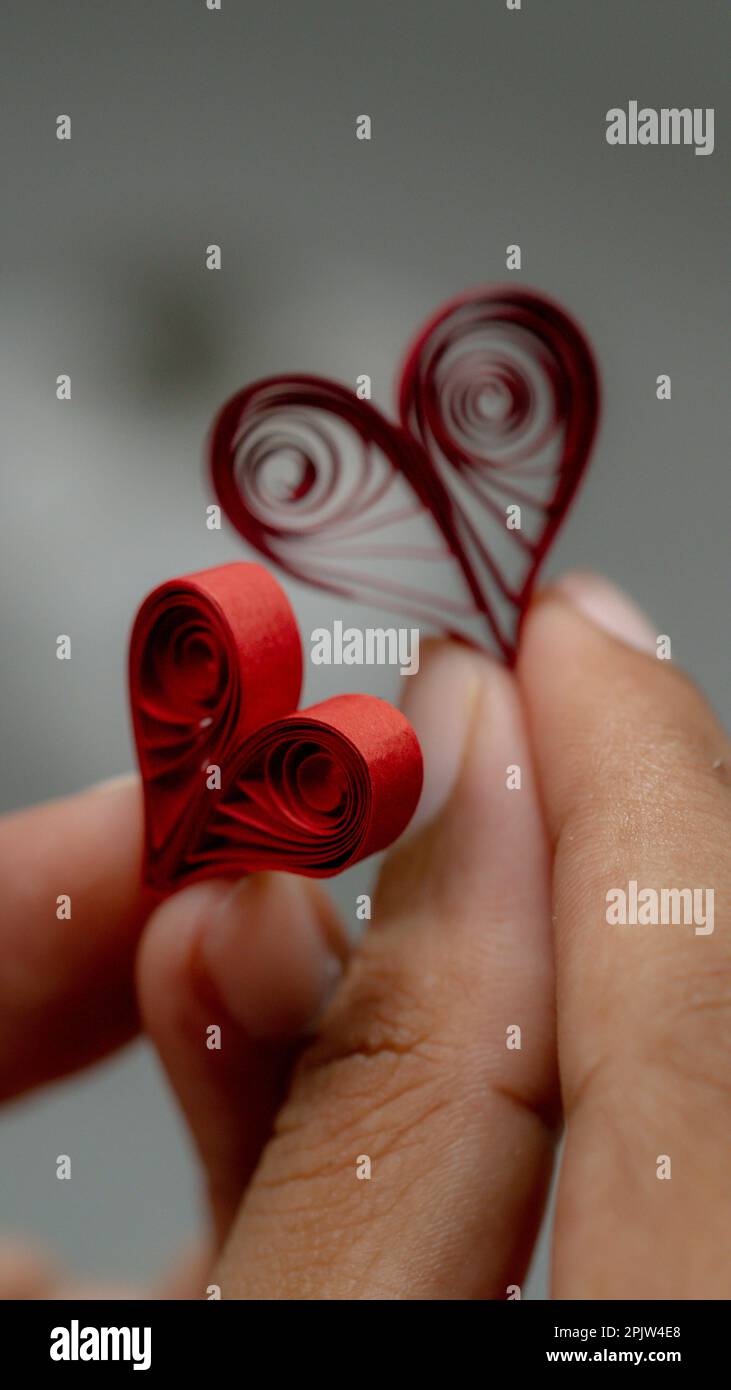 Valentinstag-Konzept. Rote Papierherzen in der Hand. Quilling Papierhandwerk Stockfoto