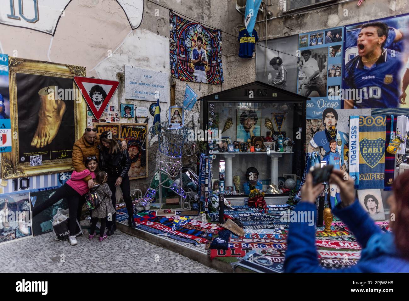 Neapel, Italien. 04. April 2023. Touristen machen Fotos an einem Schrein des ehemaligen argentinischen Fußballers Diego Maradona in der Via Emanuele de Deo. SSC Neapel, dem die Meisterschaft in der aktuellen Saison der Serie A fast unmöglich wegzunehmen ist, wurde zuletzt 1990 in Italien mit dem argentinischen Stuperstar Maradona Champion (zu dpa „Neapel bereit für die größte Fußballmeisterschaftsparty – „wird jeder verrückt?“). Kredit: Oliver Weiken/dpa/Alamy Live News Stockfoto