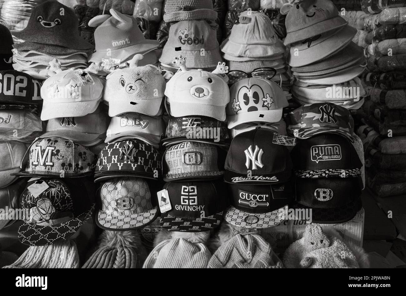 Gefälschte und gefälschte Designer-Kappen und -Hüte zum Verkauf auf dem Zentralmarkt in Pleiku, Vietnam. Stockfoto