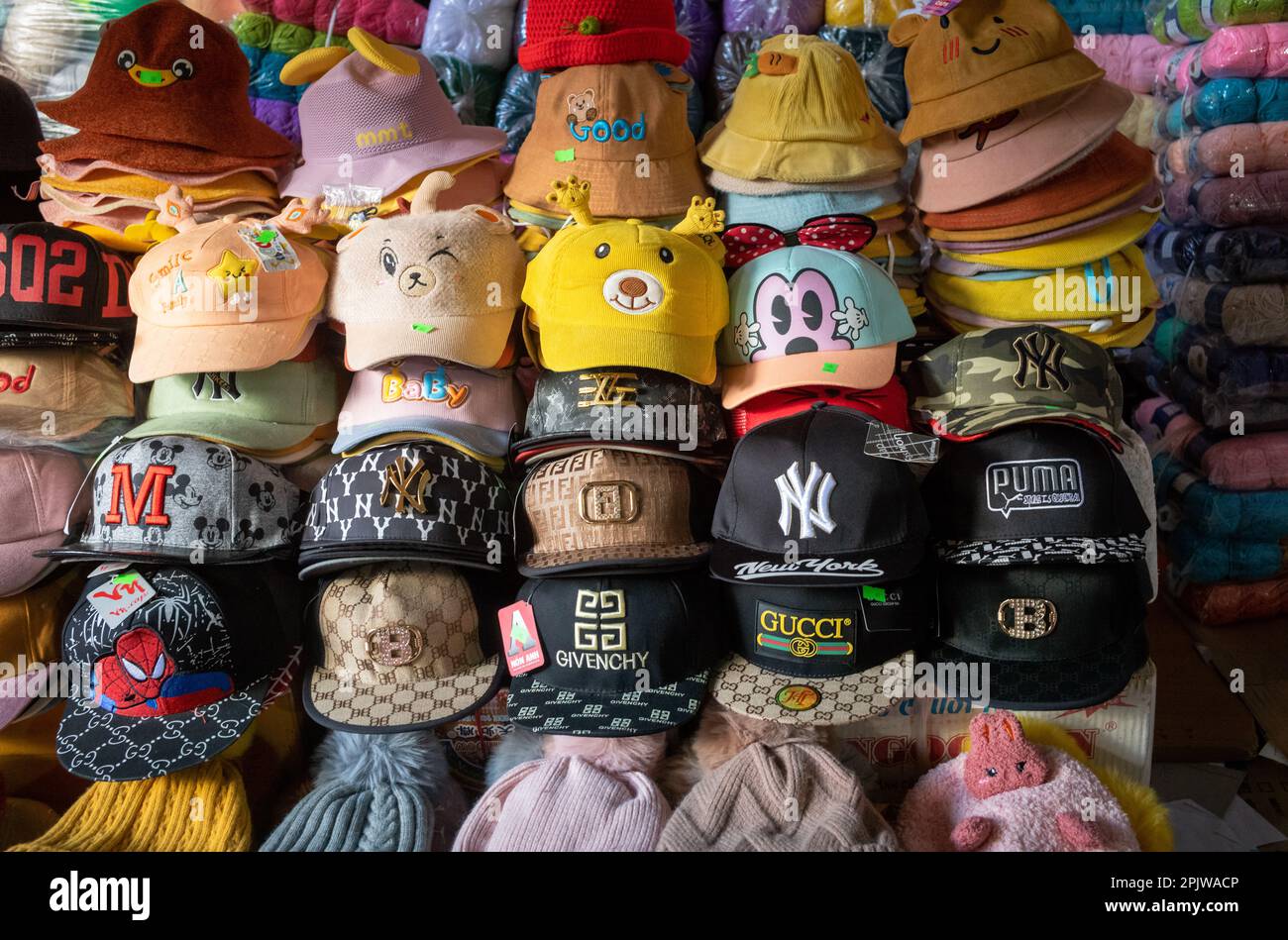 Gefälschte und gefälschte Designer-Kappen und -Hüte zum Verkauf auf dem Zentralmarkt in Pleiku, Vietnam. Stockfoto