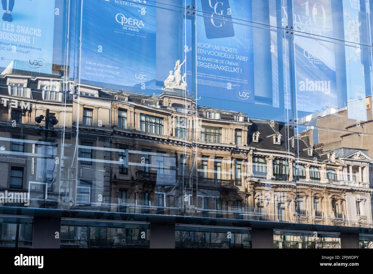Reflexionen der Gebäude rund um den Place de Brouckère in Brüssel an der Glasfassade eines Kinos. Stockfoto