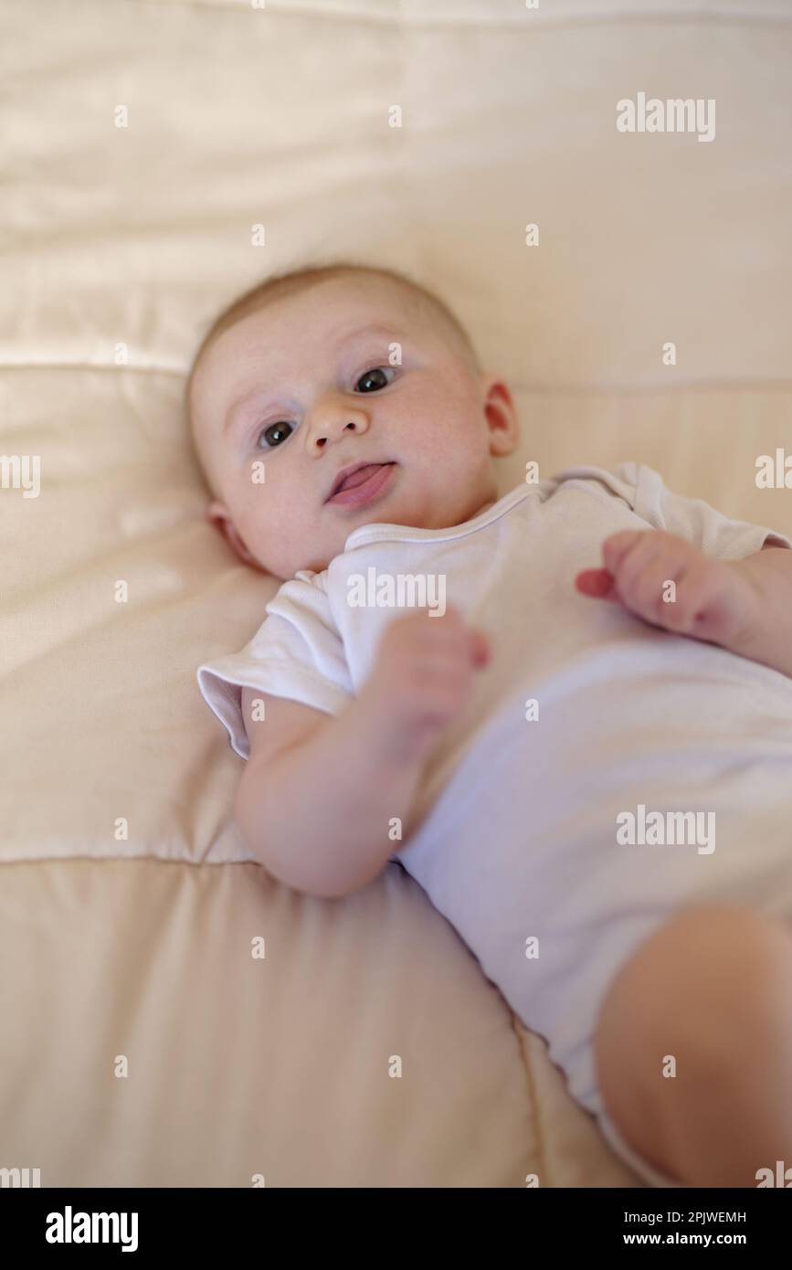 Ein 3 Monate alter Junge, der auf einem Bett liegt Stockfoto